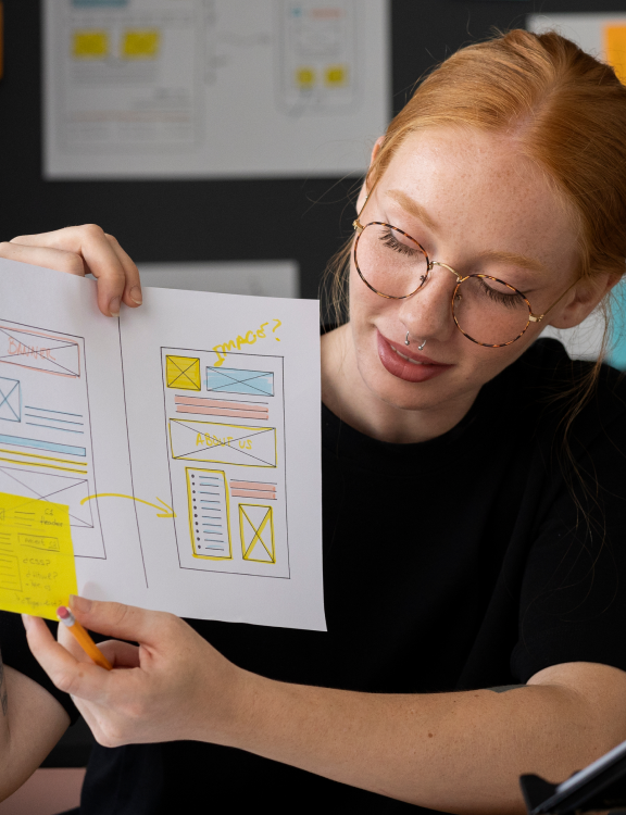 Designer examining a UI wireframe sketch for a web project